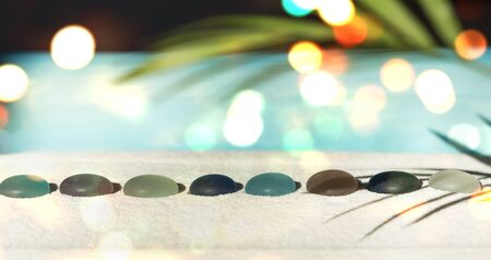 Zen garden with colorful pebbles and glitter lightの写真素材