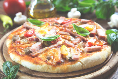 Homemade rustic pizza on wooden boardの写真素材