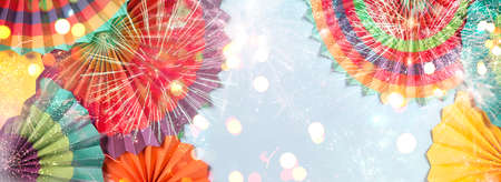 Holiday background with colorful paper ornaments and glitter light
