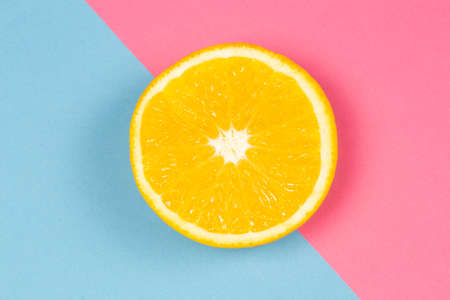 Orange half on pink and blue modern backgroundの写真素材