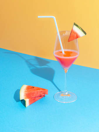 Watermelon coctail with slices against pastel blue and baige background. Minimal nature composition. Summer sunshine shadow.の写真素材