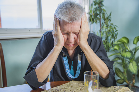 Senior elderly lady having a strong and throbbing headacheの写真素材