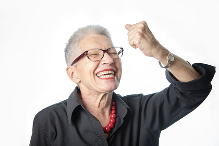 Senior old lady cheering victoriously, proud of her achievementの写真素材