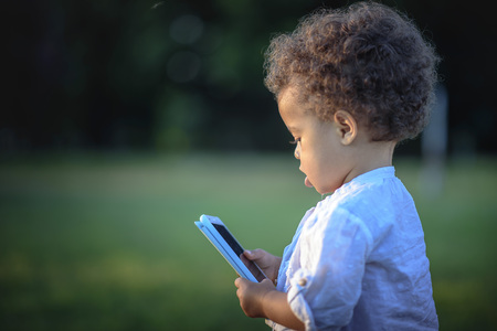 Young mixed race baby girl using a smart phoneの写真素材