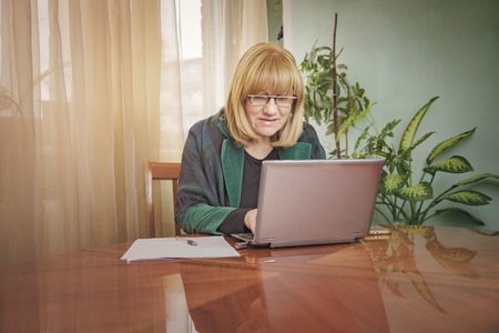 Senior business woman working on her laptop from her home officeの写真素材