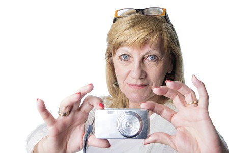 Retired senior woman using her compact camera to take some snapshots, white background