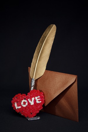 Love letters: quill, envelope and a heart seal for the most romantic present, valentines day concept, black backgroundの写真素材
