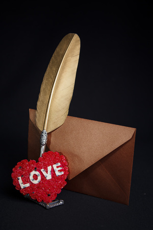 Love letters: quill, envelope and a heart seal for the most romantic present, valentines day concept, black backgroundの写真素材