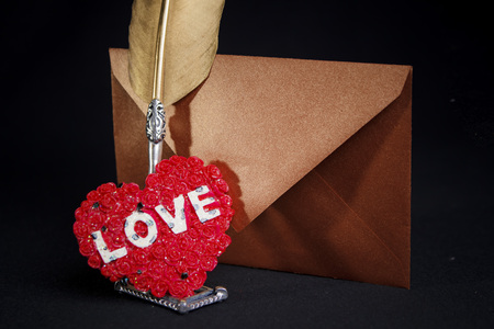 Love letters: quill, envelope and a heart seal for the most romantic present, valentines day concept, black backgroundの写真素材
