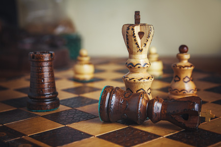 Battle concept, chest figures on a wooden chess board