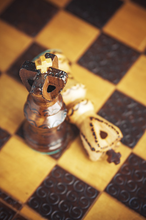 Battle concept, chest figures on a wooden chess boardの写真素材