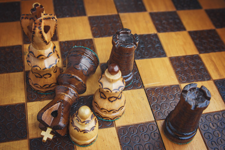 Battle concept, chest figures on a wooden chess boardの写真素材