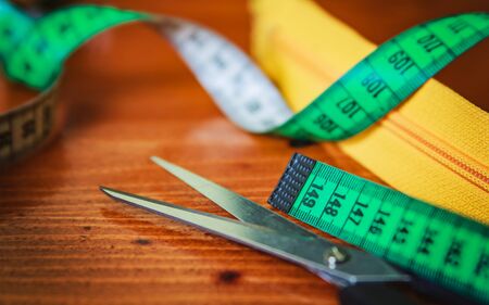 Clothing tools and accessories, scissors, measuring tape, and a roll of threadの写真素材