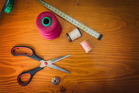 Clothing tools and accessories, scissors, measuring tape, and a roll of threadの写真素材