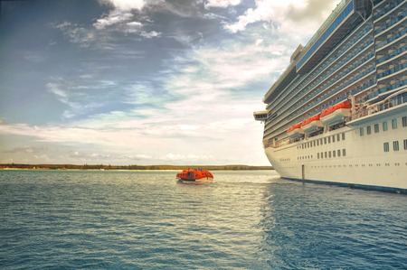 MARCH, 2015 - ST. THOMAS, CARIBBEAN: Big cruise ship docked in the middle of the ocean on the clear water, dramatic sky and sunのeditorial素材