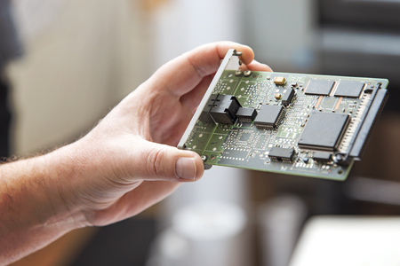 Young mans hand holding a network hardware card, closeupの写真素材