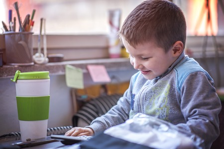 Cute little toddler boy using a calculator, figuring out a math problem, developing logic skillsの写真素材