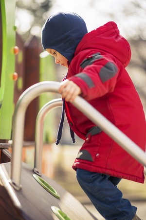 Cute little boy toddler climbing the children fort in the playground, having funの写真素材
