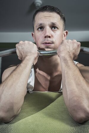 Barbell exercise, strong sexy man doing workouts to maintain his body strength