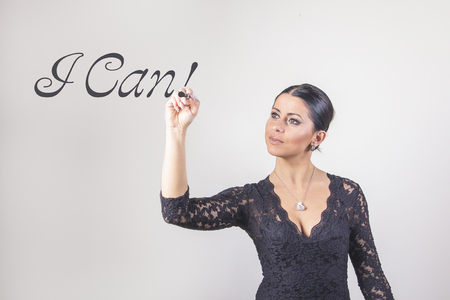 Young business coach writing out the words I can in the airの写真素材