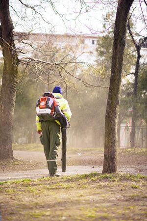 JANUARY 2018, BELGRADE SERBIA - Man operating a heavy duty leaf blower clearing the yard of fallen leavesのeditorial素材