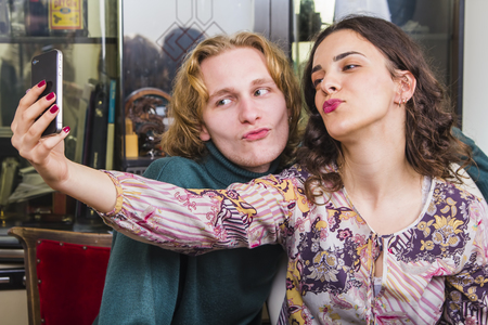 Young cute couple taking a goofy and funny selfie, making duck facesの写真素材