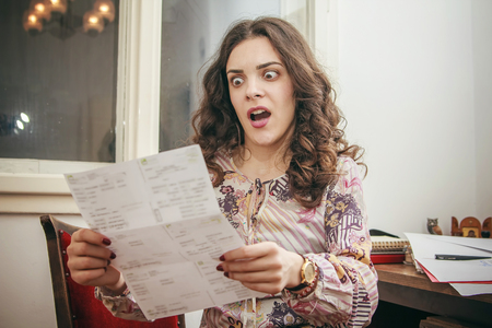 Shocked young woman cant believe the amount of money on her electricity, cable or credit  card billsの写真素材