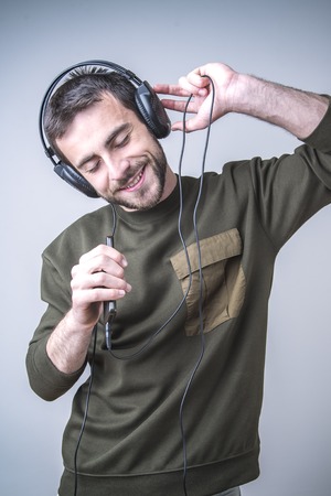 Young man dancing to the sound of the music, singing karaoke