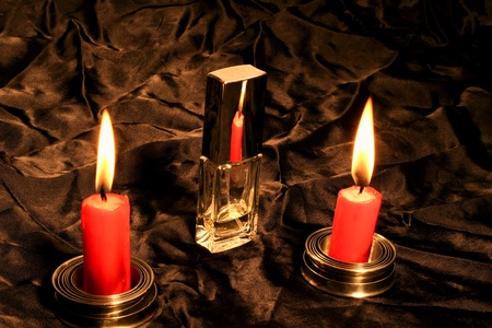 two candles reflex on bottle of perfumeの写真素材