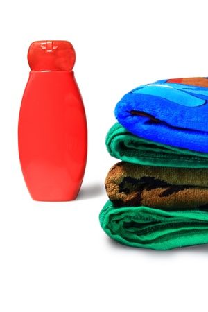 a bottle of shampoo and a pile of towels on the white backgroundの写真素材