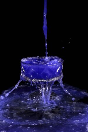 a crystal vase with blue liquid on the black backgroundの写真素材