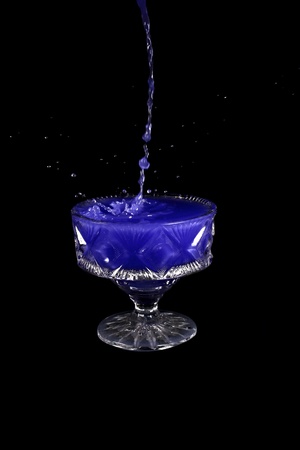 a crystal vase with blue liquid on the black backgroundの写真素材