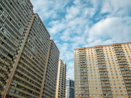 Fragment of a modern building against the sky. High-rise apartment buildings. Orange, brown and...