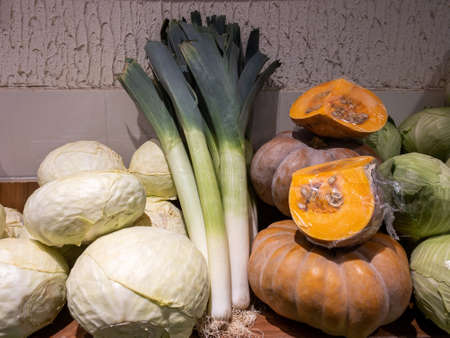 Home harvest - pumpkin, cabbage, leeks. Autumn vegetables in spring from farms and greenhouses. Wood and concrete backgroundの写真素材