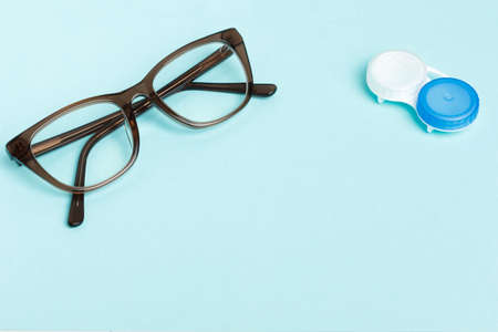 Glasses and lenses for vision correction on a colored background, top view. Ophthalmologist...