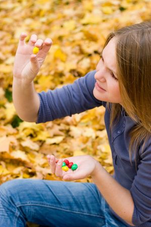 Girl resting in autumn forest, looking at falling leafsの写真素材