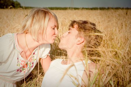 Image of young man and woman on wheat fieldの写真素材