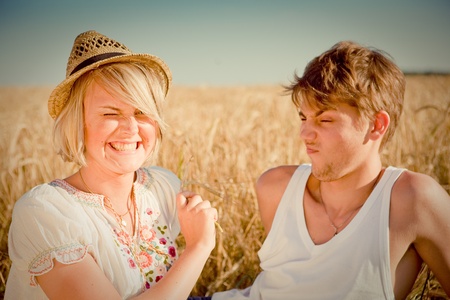 Image of young man and woman on wheat fieldの写真素材