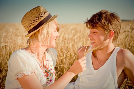 Image of young man and woman on wheat fieldの写真素材