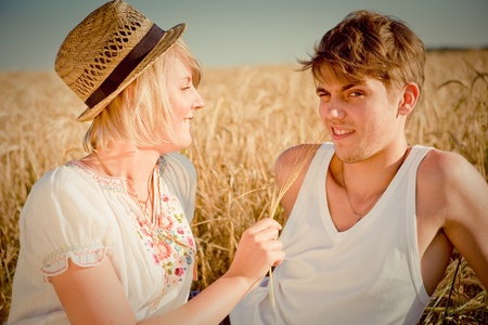Image of young man and woman on wheat fieldの写真素材