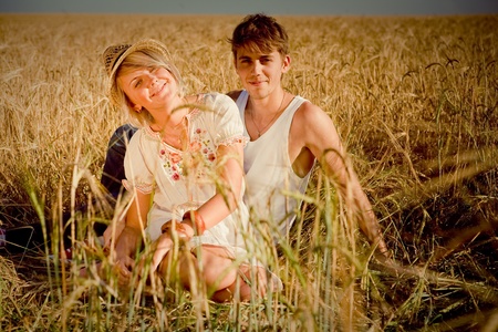 Image of young man and woman on wheat fieldの写真素材