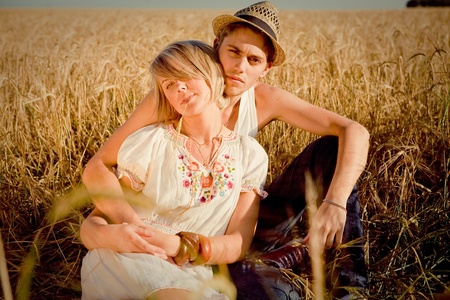 Image of young man and woman on wheat fieldの写真素材