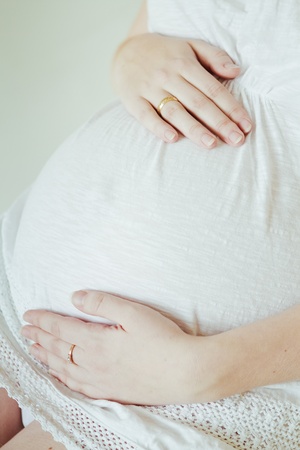 Beautiful young pregnant woman sitting on chairの写真素材