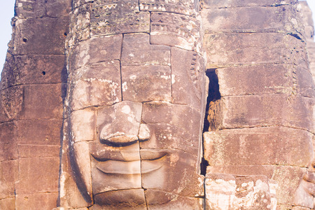 Stone face statue in ancient Bayon Temple Angkor Thom, Cambodia. Ancient monument Khmer architecture.の写真素材