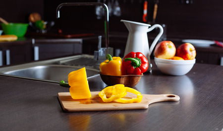 Yellow bell pepper on cutting board in the kitchenの写真素材