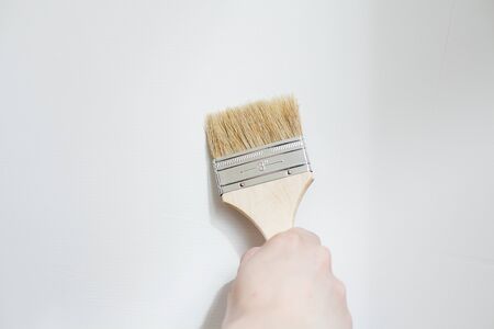 Painter painting the white wall in house. Close up brushの写真素材