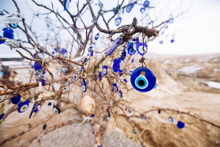 Nazar, charms to ward off the evil eye , on the branches of a tree in Cappadocia, Turkeyの写真素材