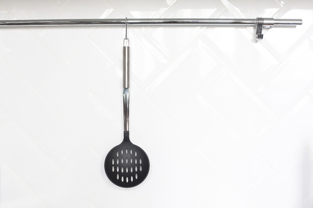 Cutlery hanging on white wall in the kitchen