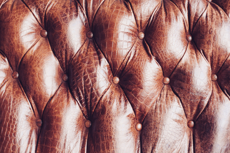 Closeup texture of vintage brown leather sofa in roomの写真素材
