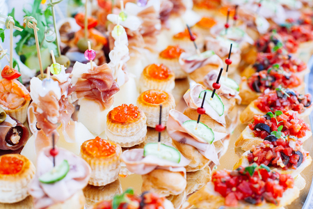Beautifully decorated catering banquet mirror table with different food snacks and appetizersの写真素材